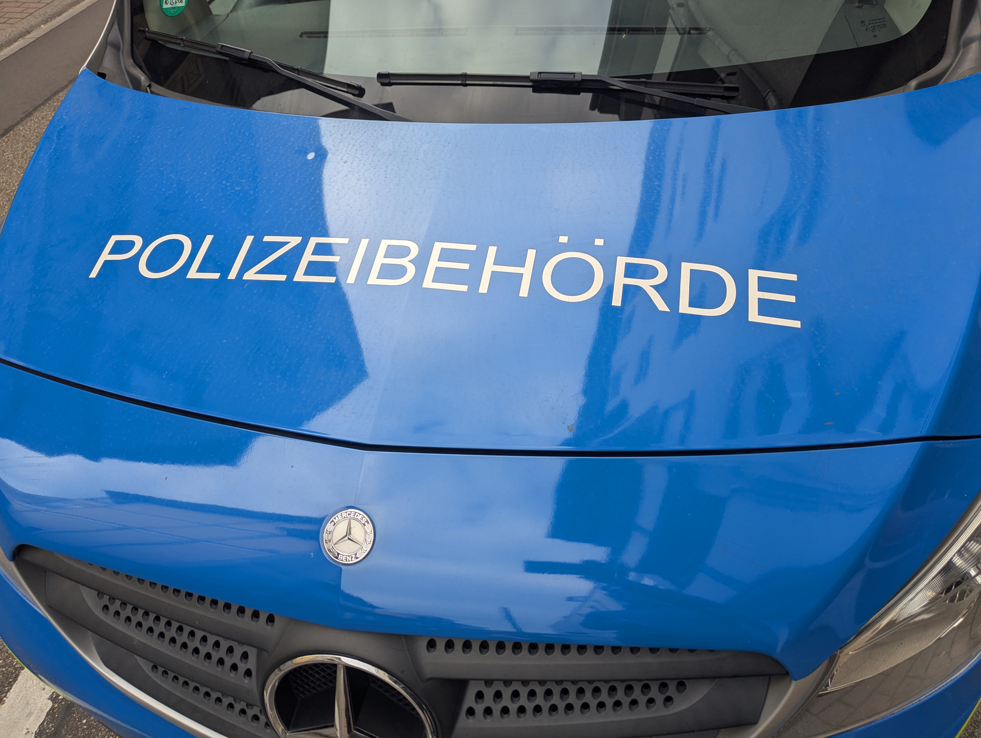 Blaue Frontpartie eines Polizeifahrzeugs mit Mercedes-Stern-Logo.